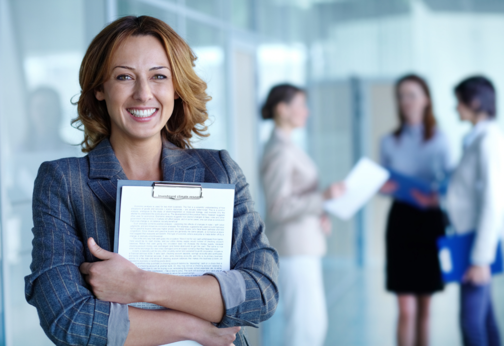 Image of a smiling woman holding a clipboard