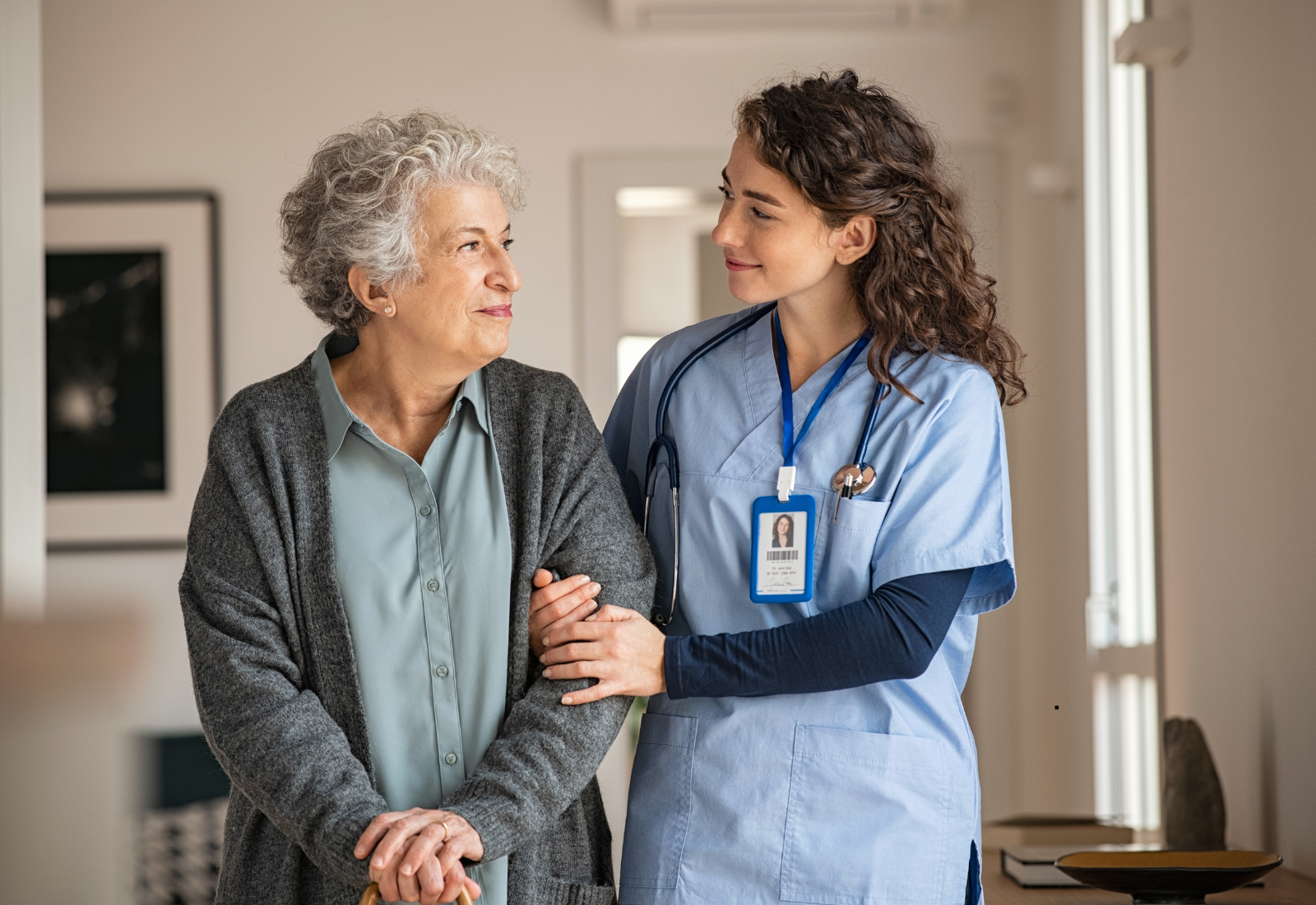 Image of a nurse walking with a resident in a nursing home