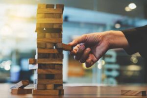 Image of a person removing a block from a Jenga tower