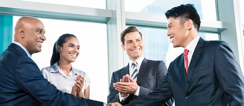 Image of business people smiling and shaking hands