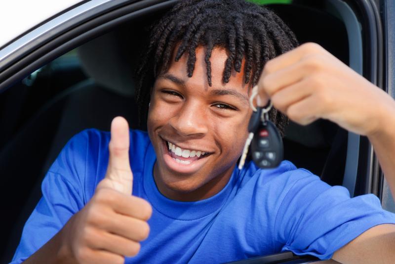 Image of a teen driver giving a thumbs up